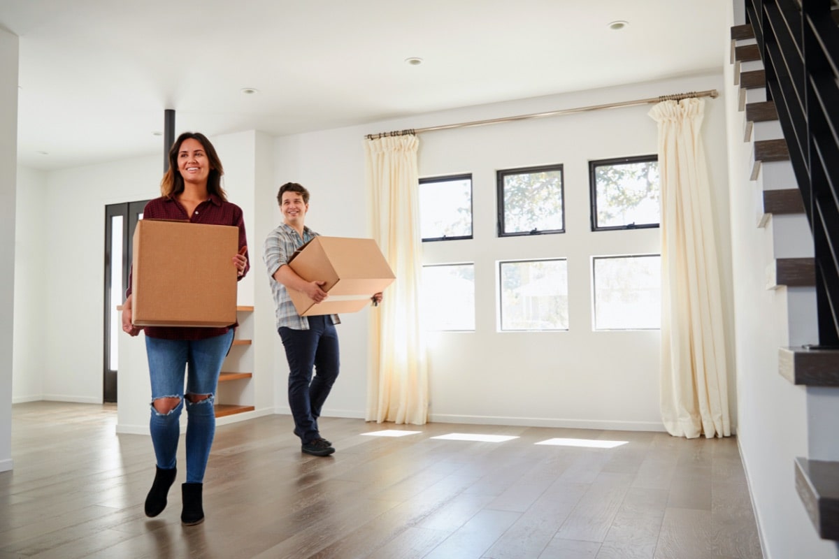 Glückliches Paar räumt neue Wohnung ein